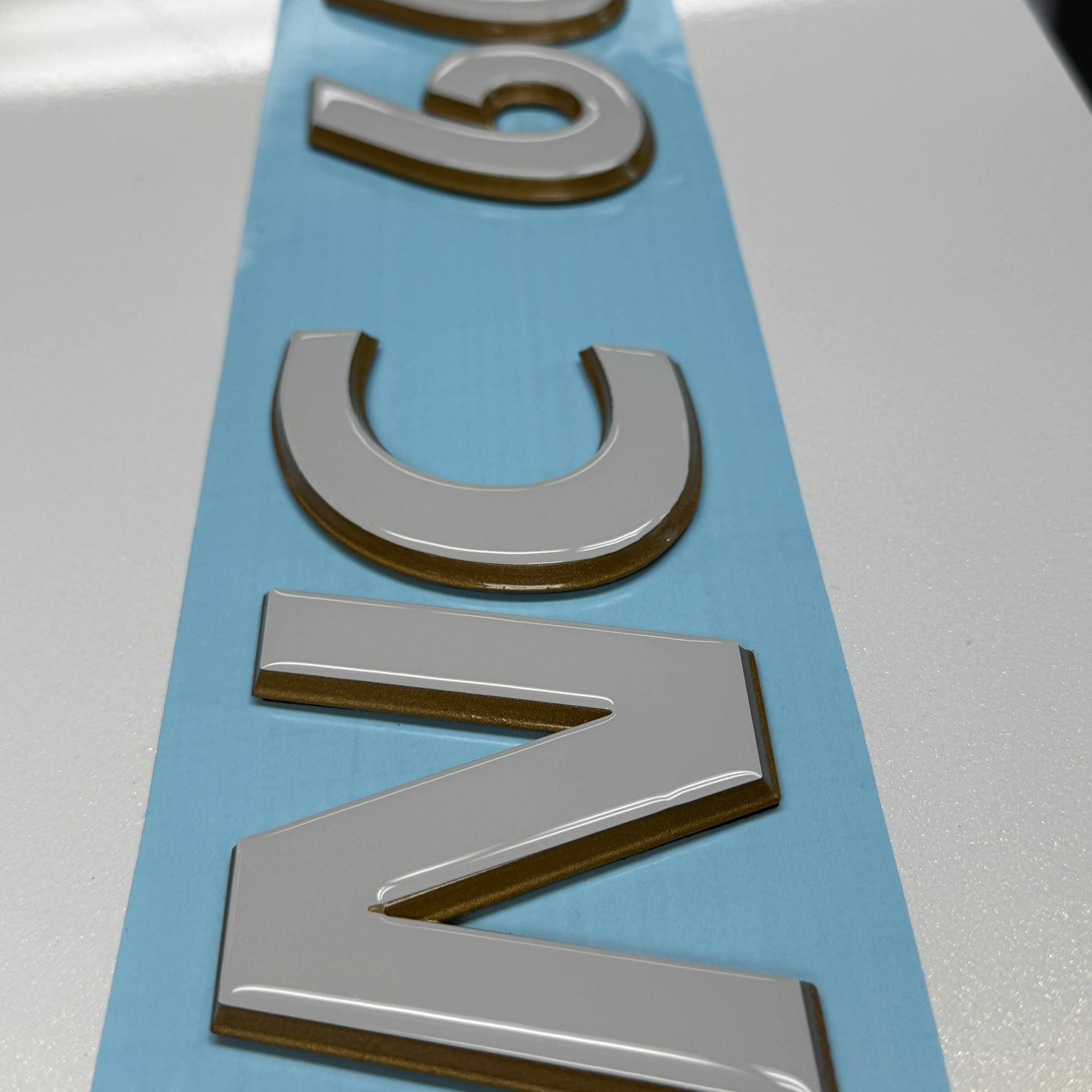 Tige Boats 3D Emblem with Domed Overlay Registration. Tige Stone and Dark Metallic Gold